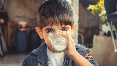 photo of boy drinking glass of milk
